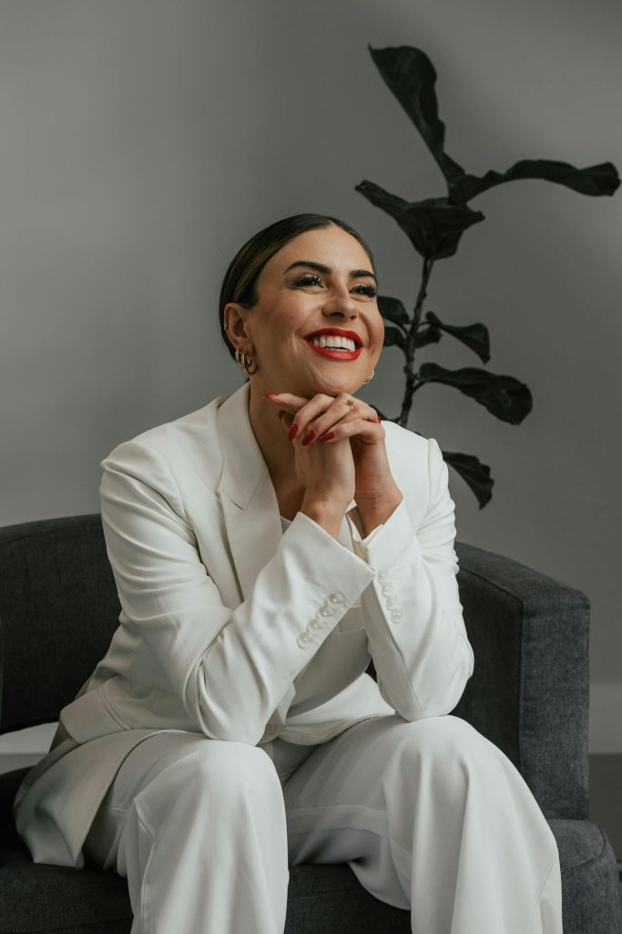 Image of woman smiling in white pant suit. Photo Courtesy of Produtora Midtrack via Pexels.com